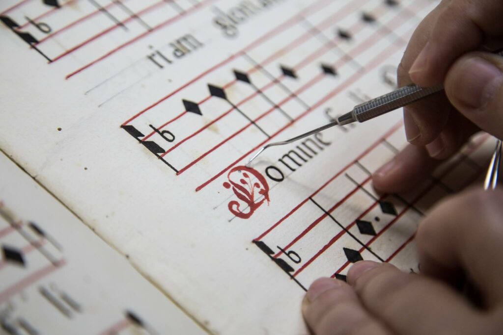 Étape du processus de restauration d'art sur une partition musicale historique.